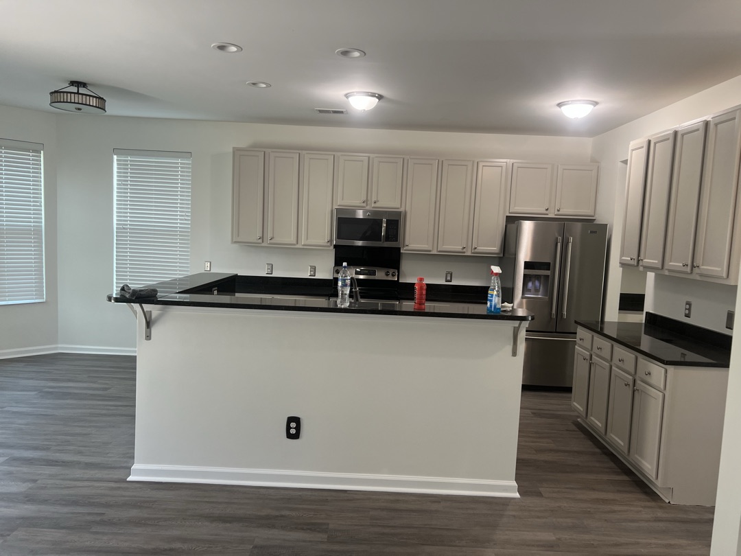 Freshly painted white kitchen cabinets with black countertops