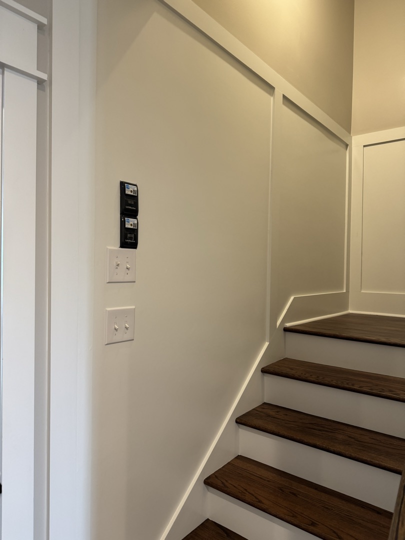Stairway with wainscoting and stained treads